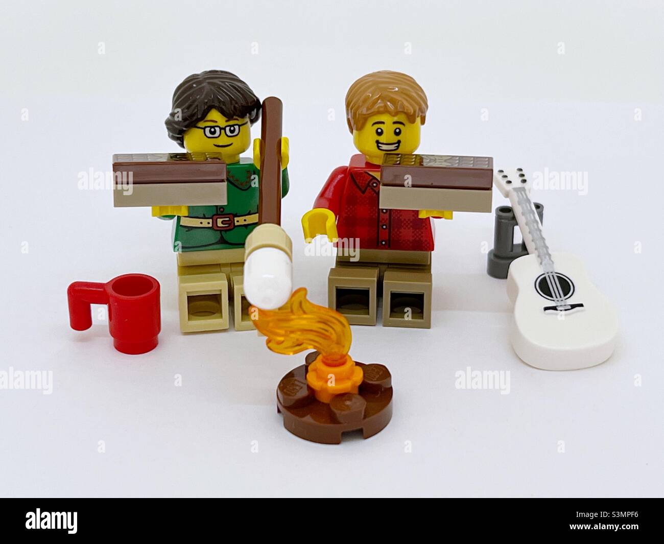 LEGO Minifiguren Toasten von Sumpftieren und machen S’mores, die mit graham Crackern, Schokolade Bonbon Bar und Marshallow gemacht wird. Stockfoto