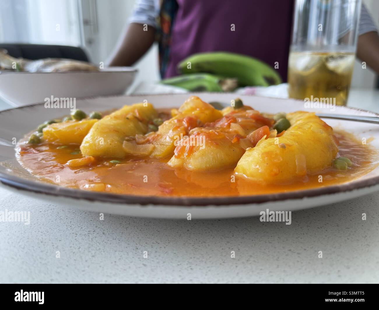 Matoke, grüner Wegerich, ostafrikanische Lebensmittel, Ndizi na Nyama ya türkei, tansanische Gerichte, Bananeneintopf, grüner Bananeneintopf, afrikanische Frau, die zu essen hat Stockfoto