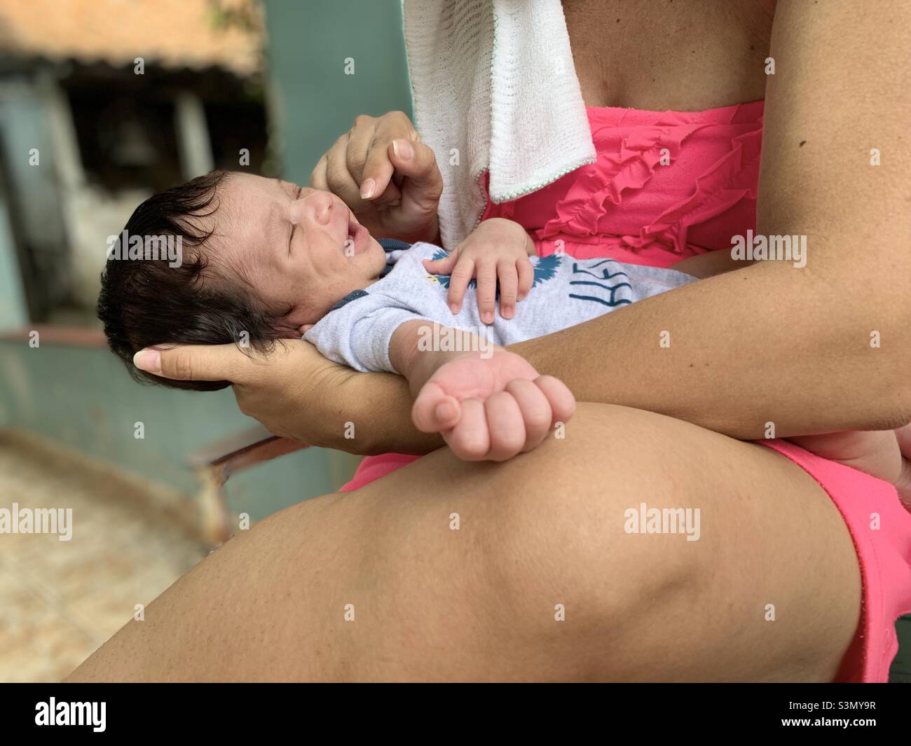 Neugeborener Junge, der in den Armen seiner Mutter lächelt. Covid -19 Babyboom. Geburtsrate, Mutterschaftskonzept. Havanna, Kuba Stockfoto