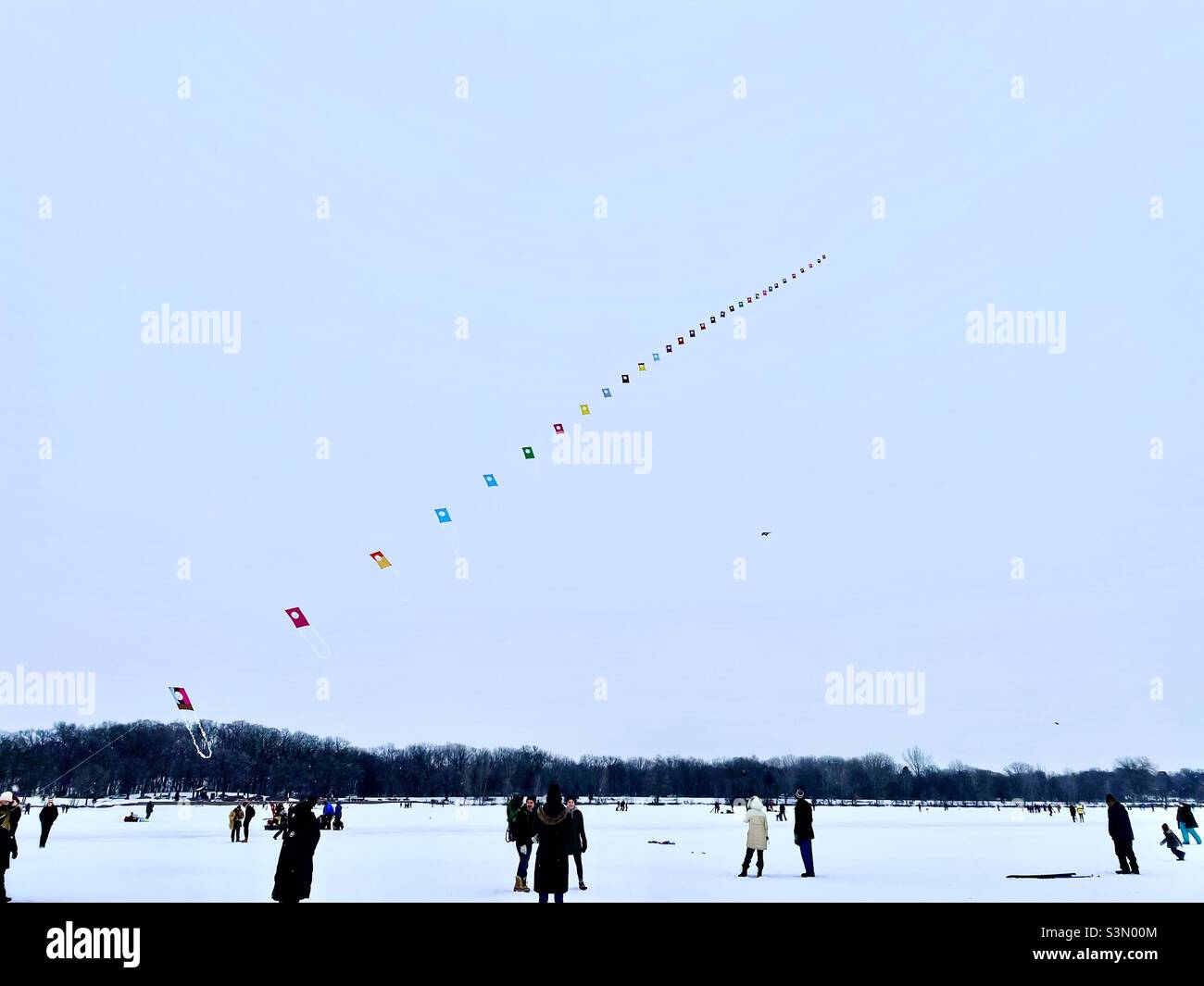 Lake Harriet Kite Festival. Ein farbenfroher koreanischer Wellendrachen, der im Januar über einem gefrorenen See in Minnesota fliegt. Stockfoto