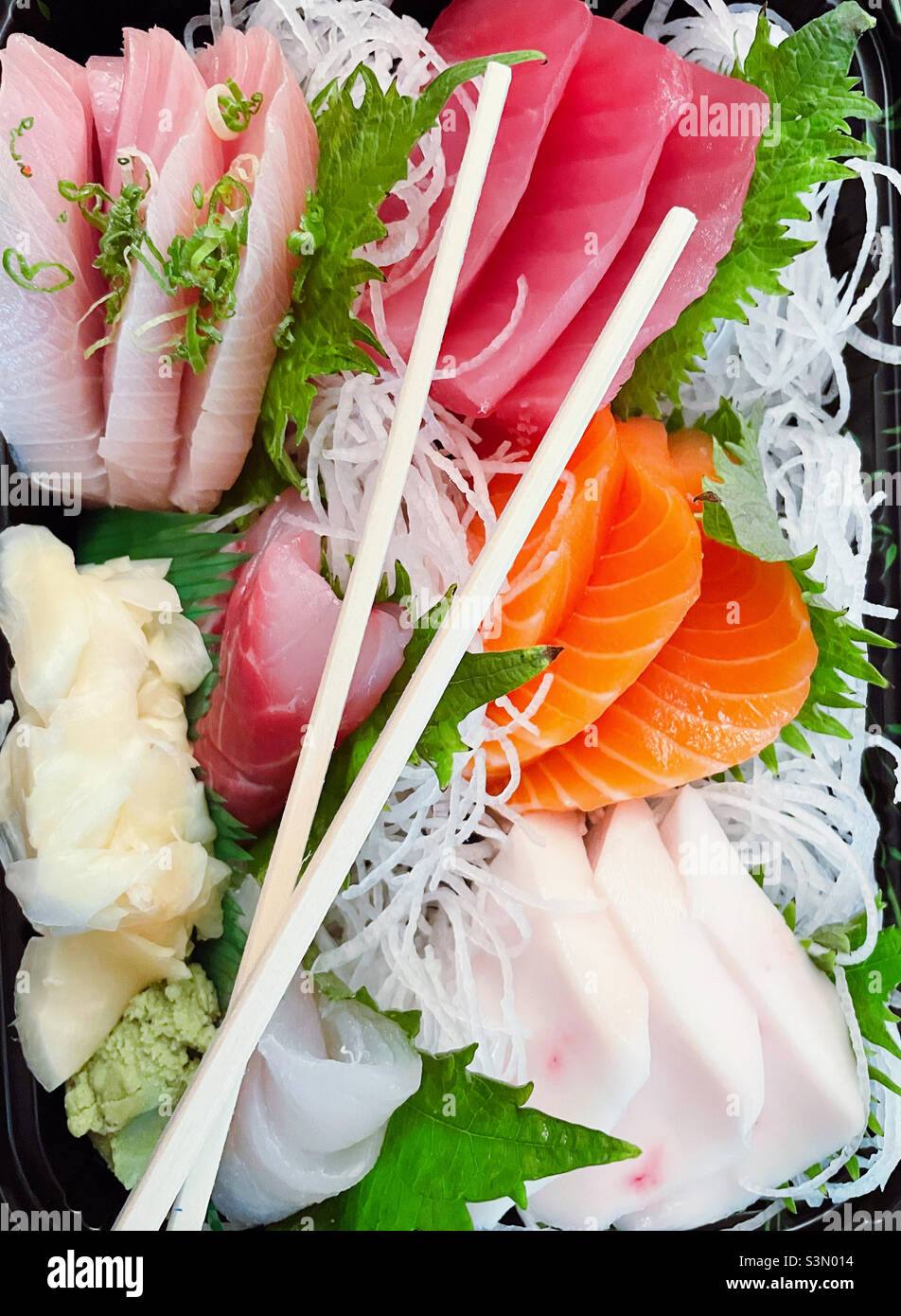 Nahaufnahme eines frischen Sashimi-Sortiments mit Holzstäbchen - Smartphone-aufgenommenes Stockfoto