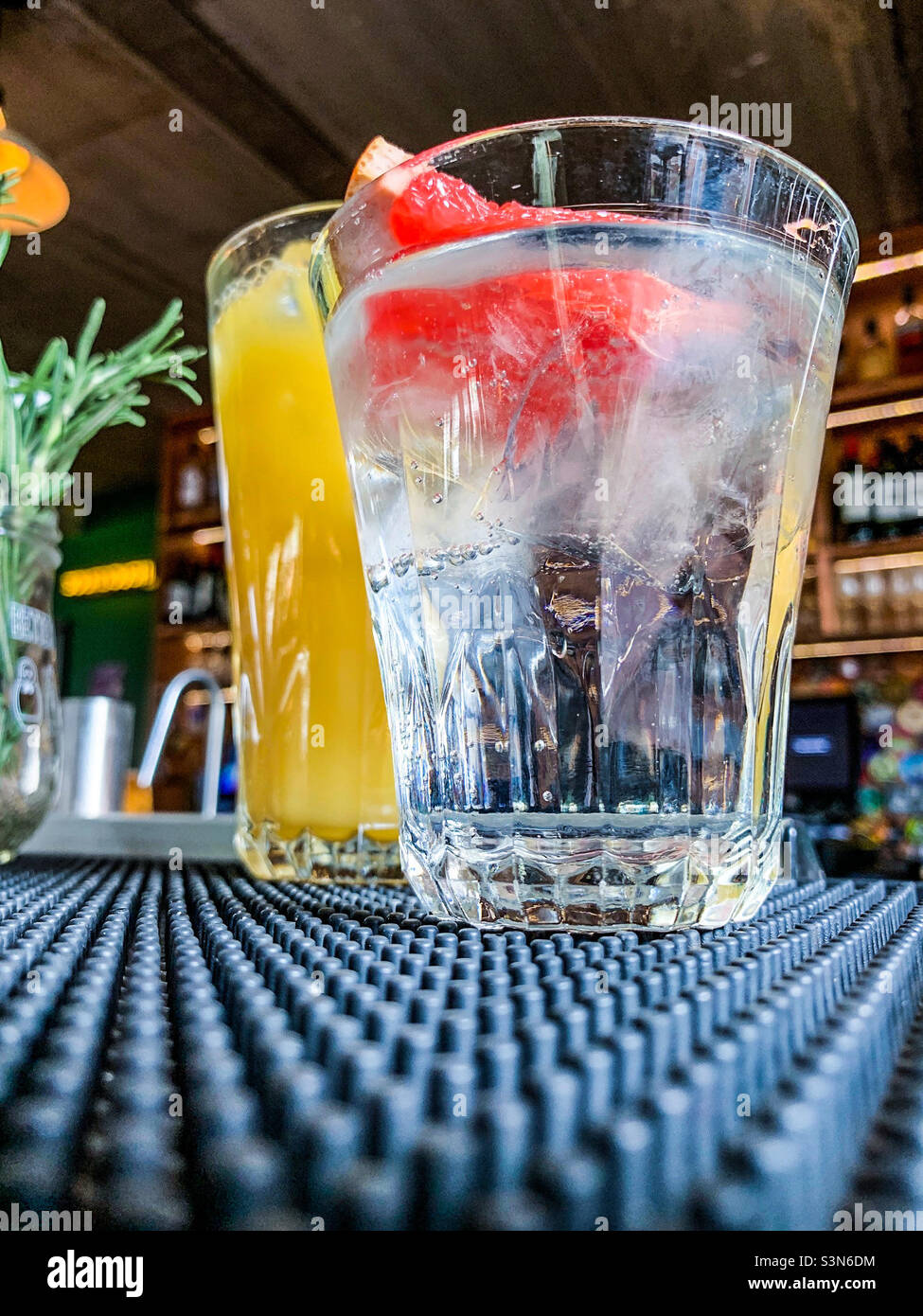 Ein Glas Gin Tonic und Orangensaft an einer Bar Stockfoto