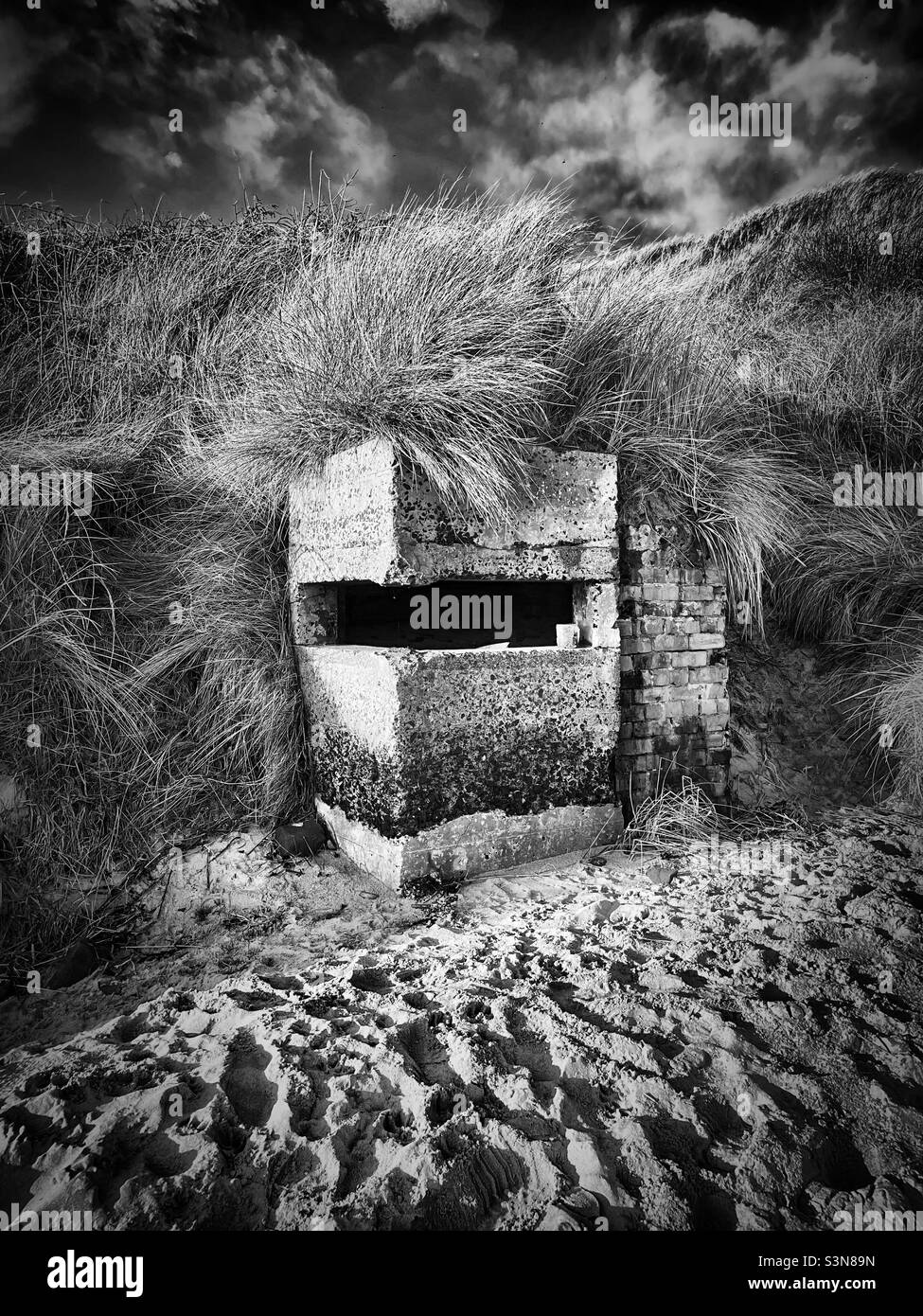 ‘Black & White History’ ein Pillbox-Bunker aus dem Zweiten Weltkrieg wird von wunderschönen Stränden und Sanddünen in Embleton Bay, Northumberland, verkleidet Stockfoto