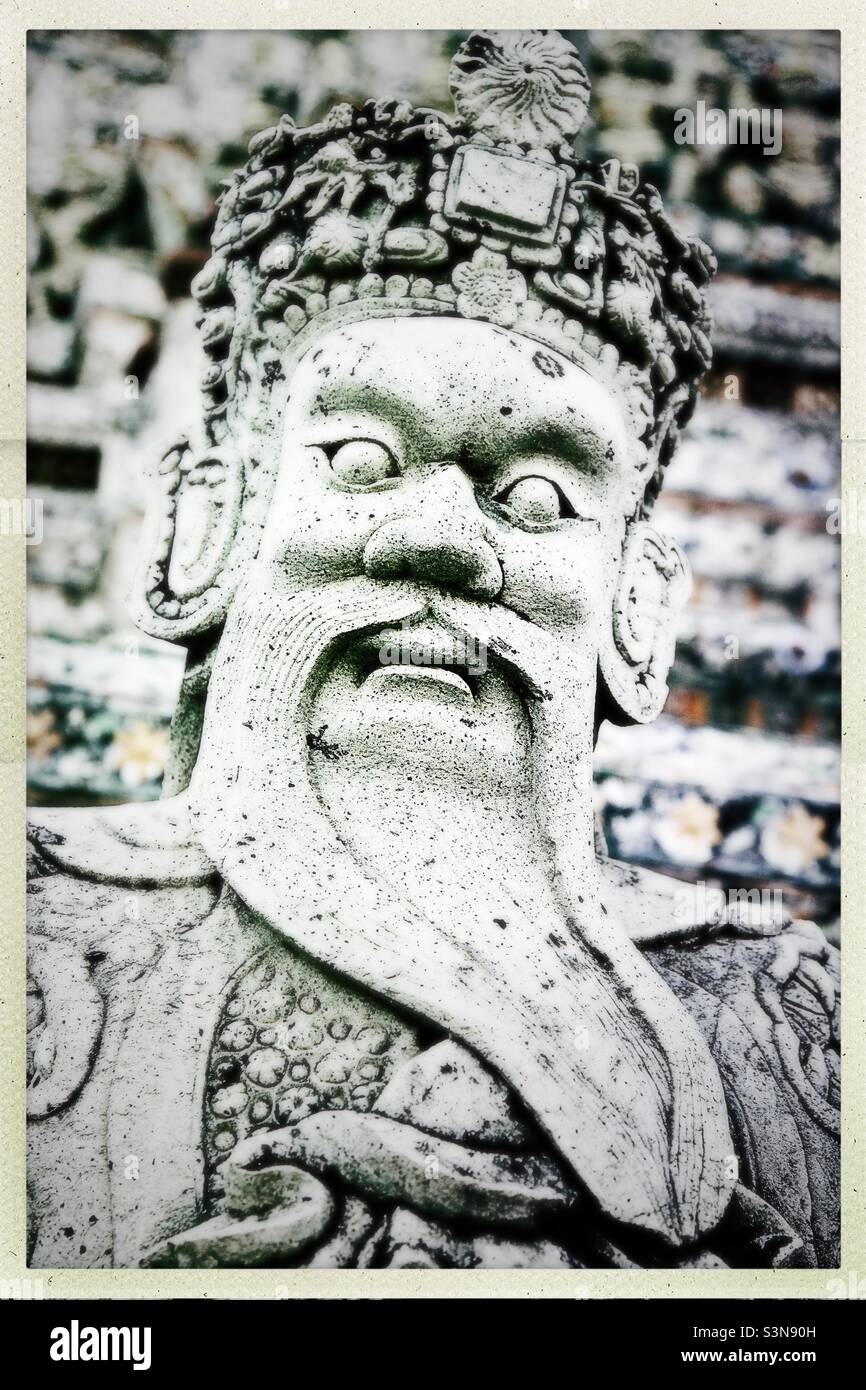 Eine Schutzstatue im Wat Arun, Bangkok, Thailand - Smartphone-aufgenommenes Stockfoto