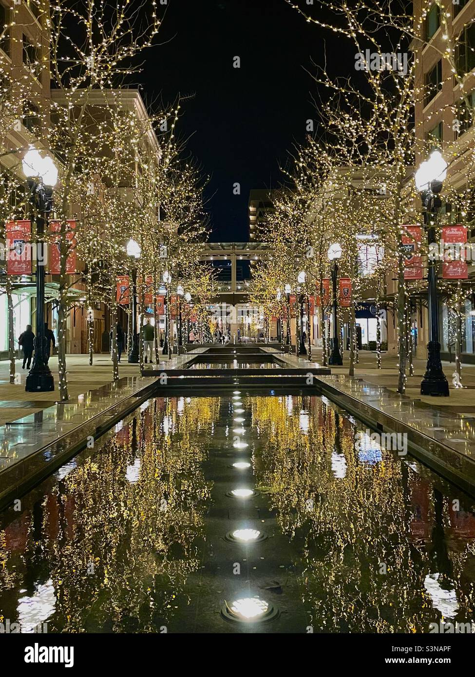 Blick in das City Creek Einkaufszentrum, vom nördlichen Eingang, in der Innenstadt von Salt Lake City, Utah, USA während der Weihnachtszeit. In den Wasserbecken spiegeln sich Lichter. Stockfoto