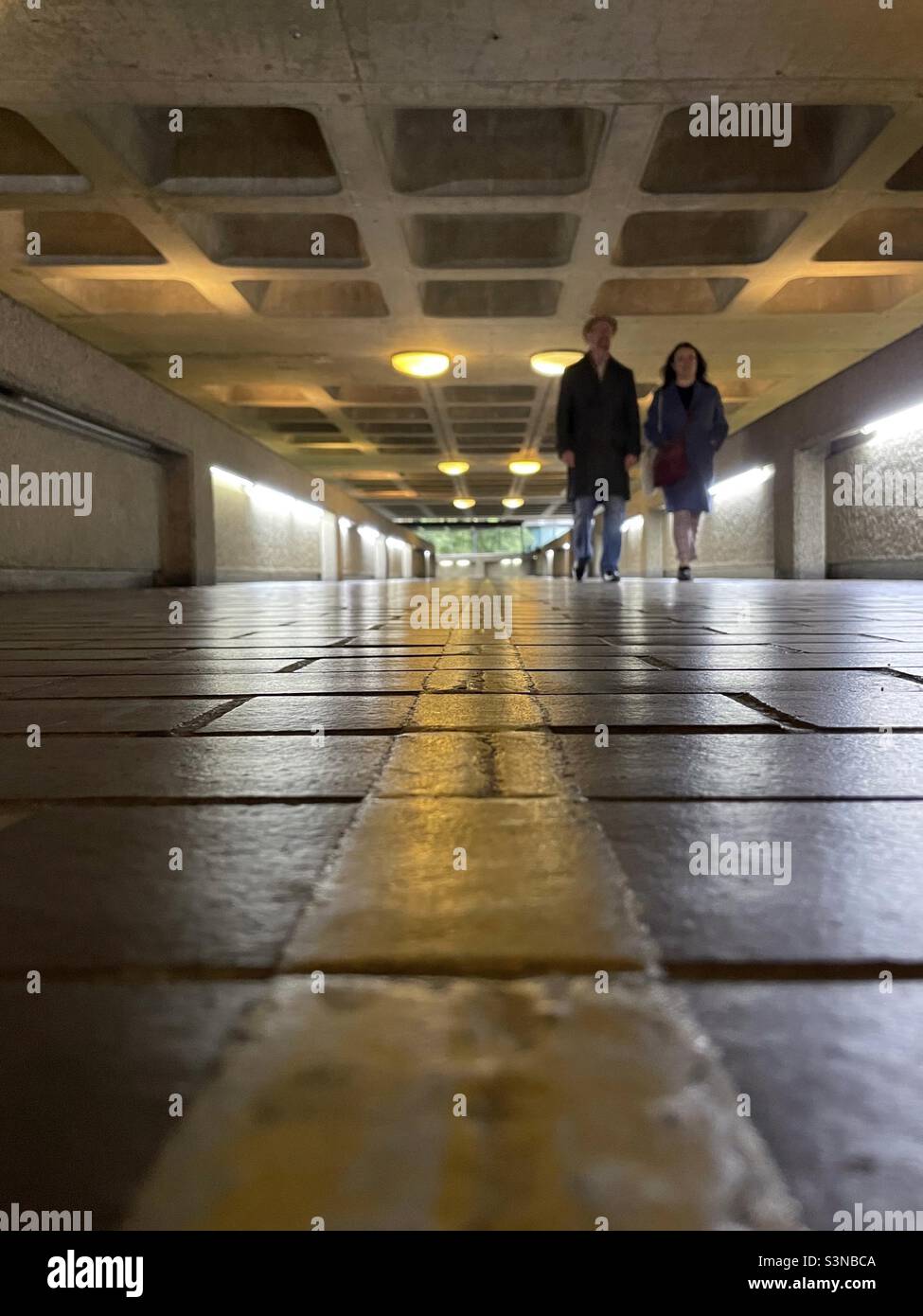 Freunde, die die Unterführung im Barbican Estate nehmen Stockfoto