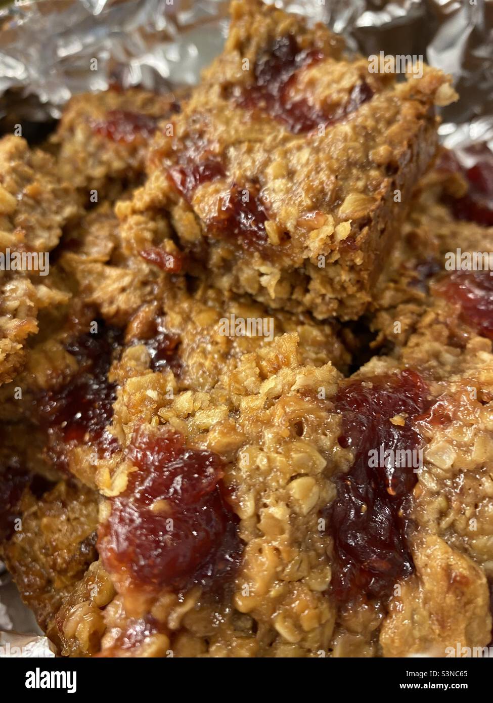 Hausgemachte Flapjacks mit Erdnussbutter und Erdbeermarmelade Stockfoto