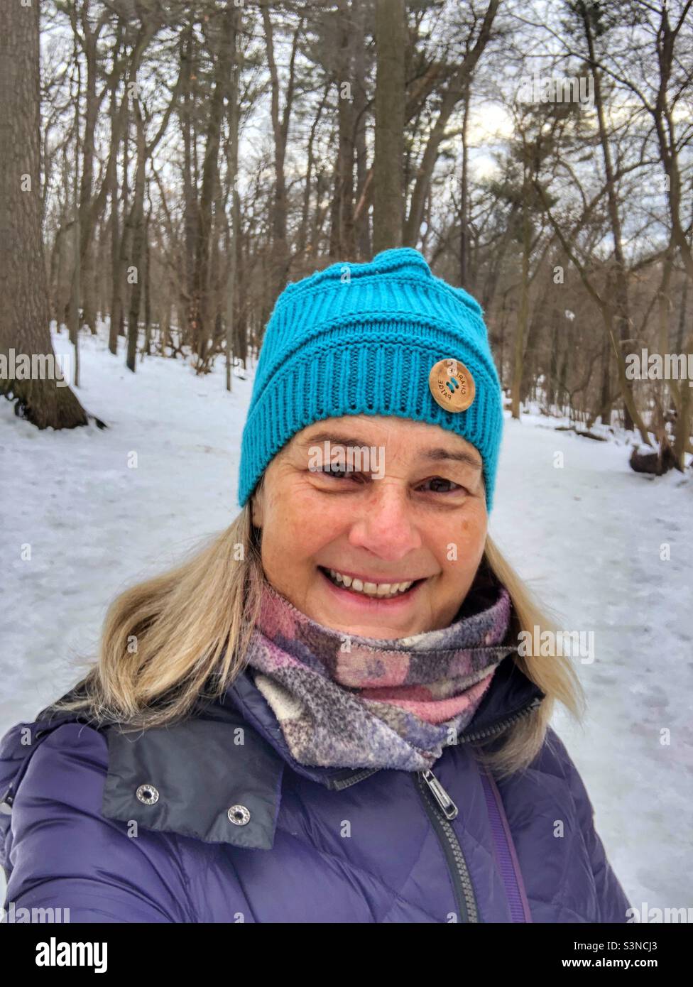 Selfie einer glücklichen Frau im Winter im Wald. Stockfoto