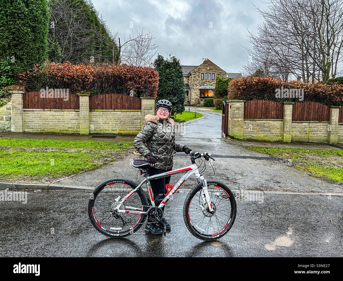 Das junge 12-jährige Mädchen stand neben ihrem Fahrrad Stockfoto
