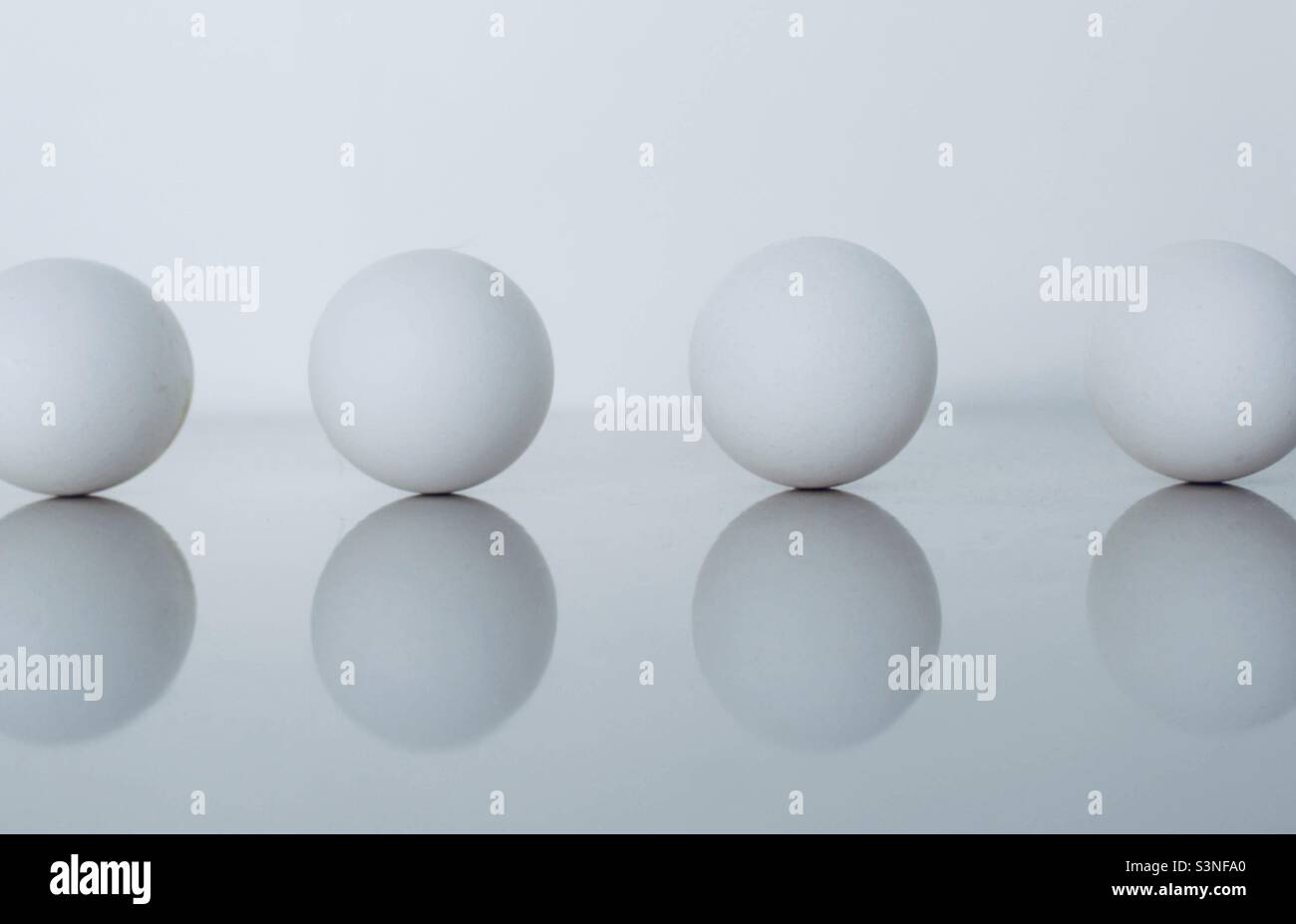 Eier in einer Reihe auf weißem Hintergrund - Smartphone-aufgenommenes Stockfoto