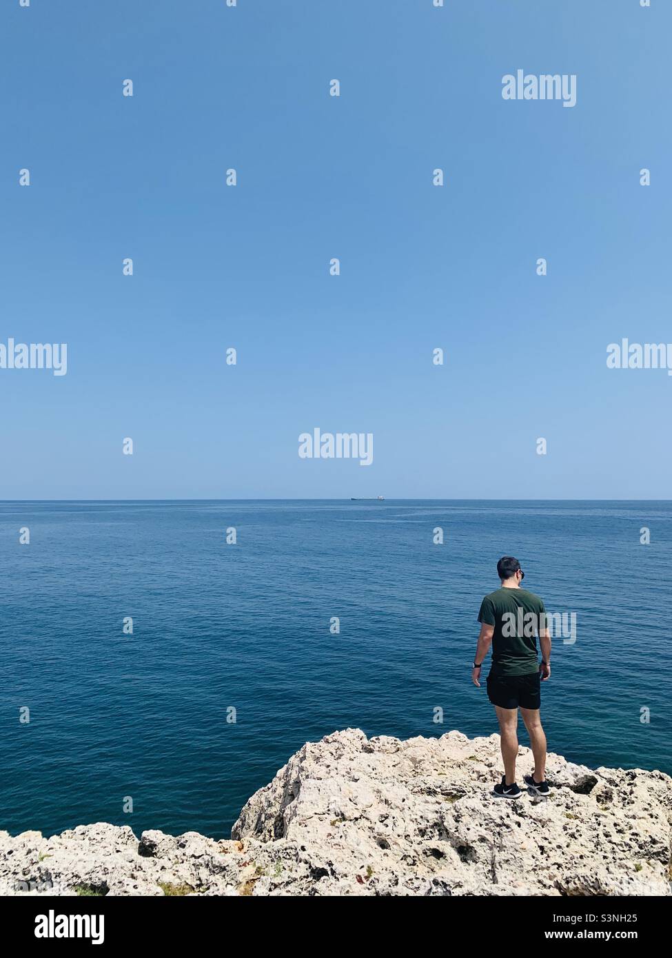 Kubanischer Mann, der auf einem Riff in der Nähe des Ozeans steht, Havanna, Kuba, Karibik Stockfoto