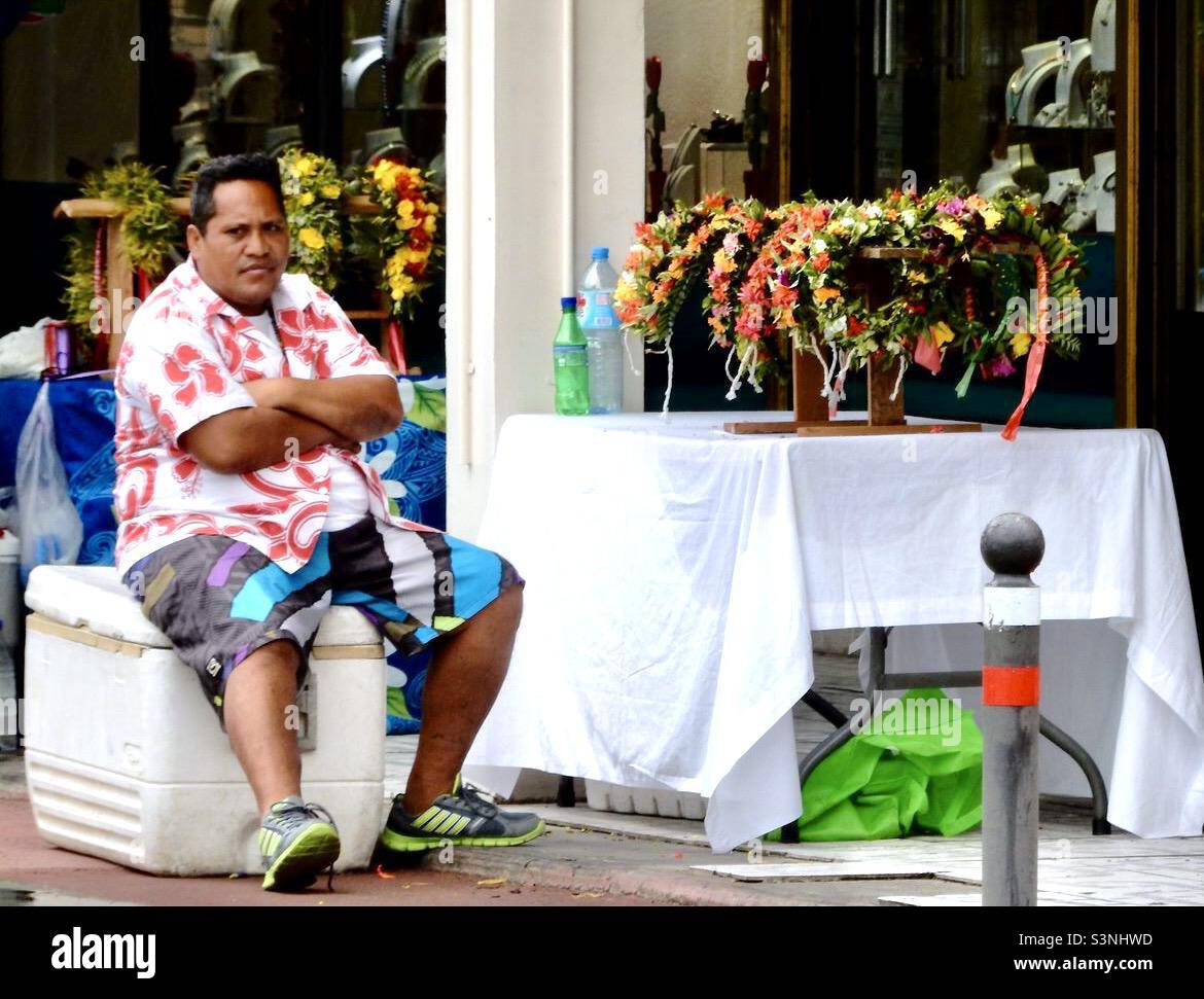 Verkäufer auf einem Papeete-Markt, der bunte Blumenkronen verkauft Stockfoto