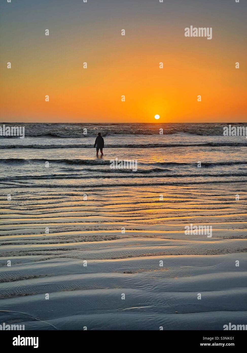 Paddeln Sie bei Sonnenuntergang in Rest Bay, South Wales. - Smartphone-aufgenommenes Stockfoto