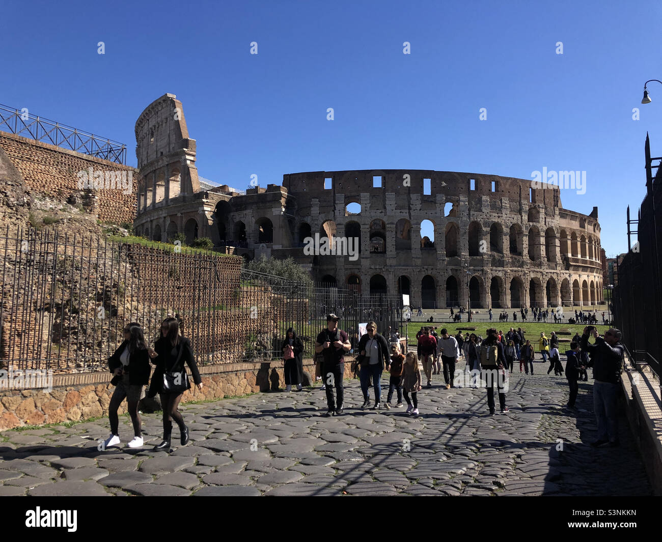 Touristen, die durch die römische historische Stätte Colosseo in Italien rom spazieren - Smartphone-aufgenommenes Stockfoto