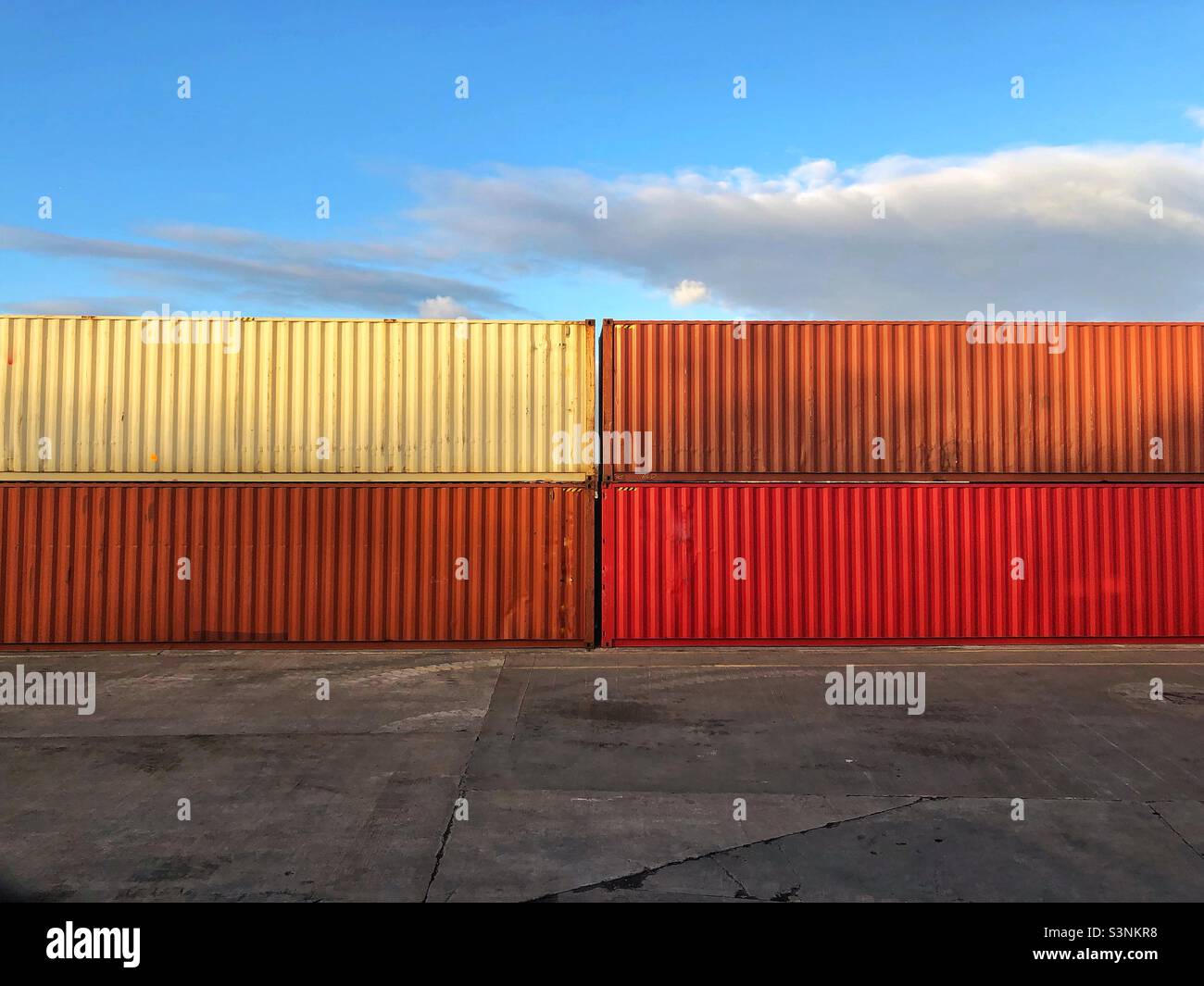 Generische bunte Transportbehälter an einem Hafendock oder Terminal mit Kopierplatz - Smartphone-aufgenommenes Stockfoto