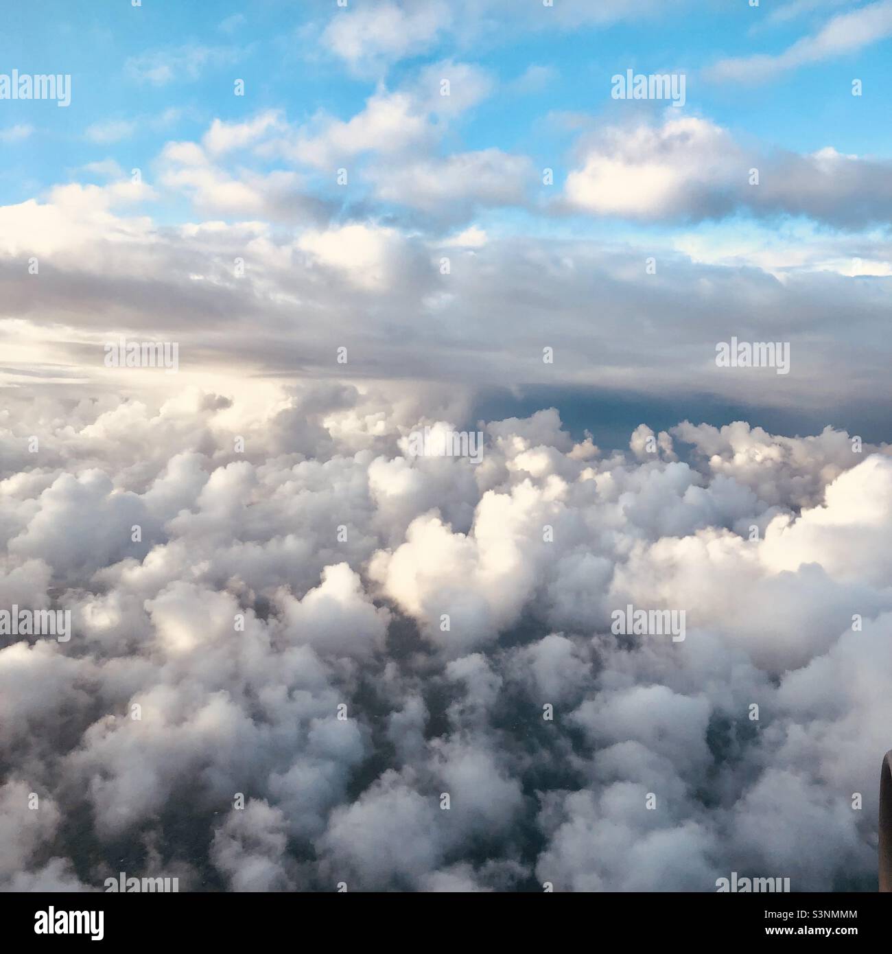 Reisefotografie Blick aus dem Flugzeug - blauer Himmel und flauschige Wolken - Smartphone-aufgenommenes Stockfoto