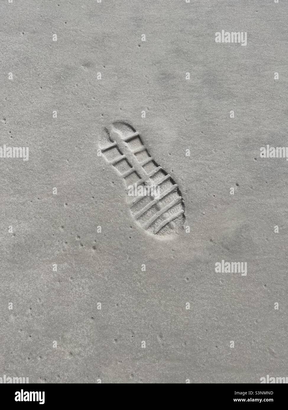 Detaillierter Schuhaufdruck auf Strandsand Stockfoto