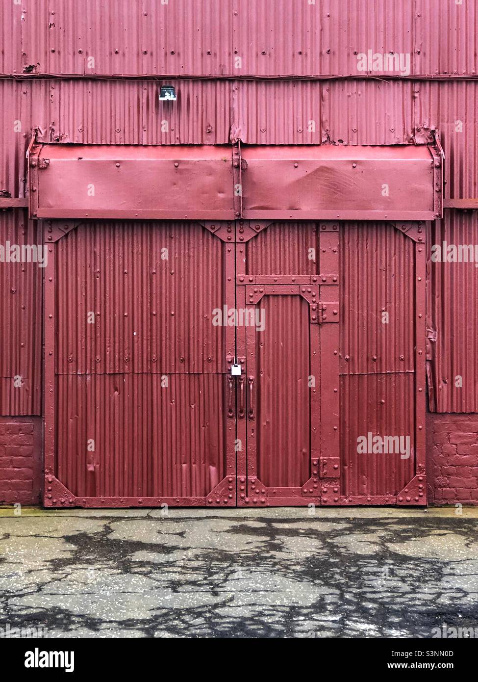 Industrietür mit Vorhängeschloss und Verschluss Stockfoto