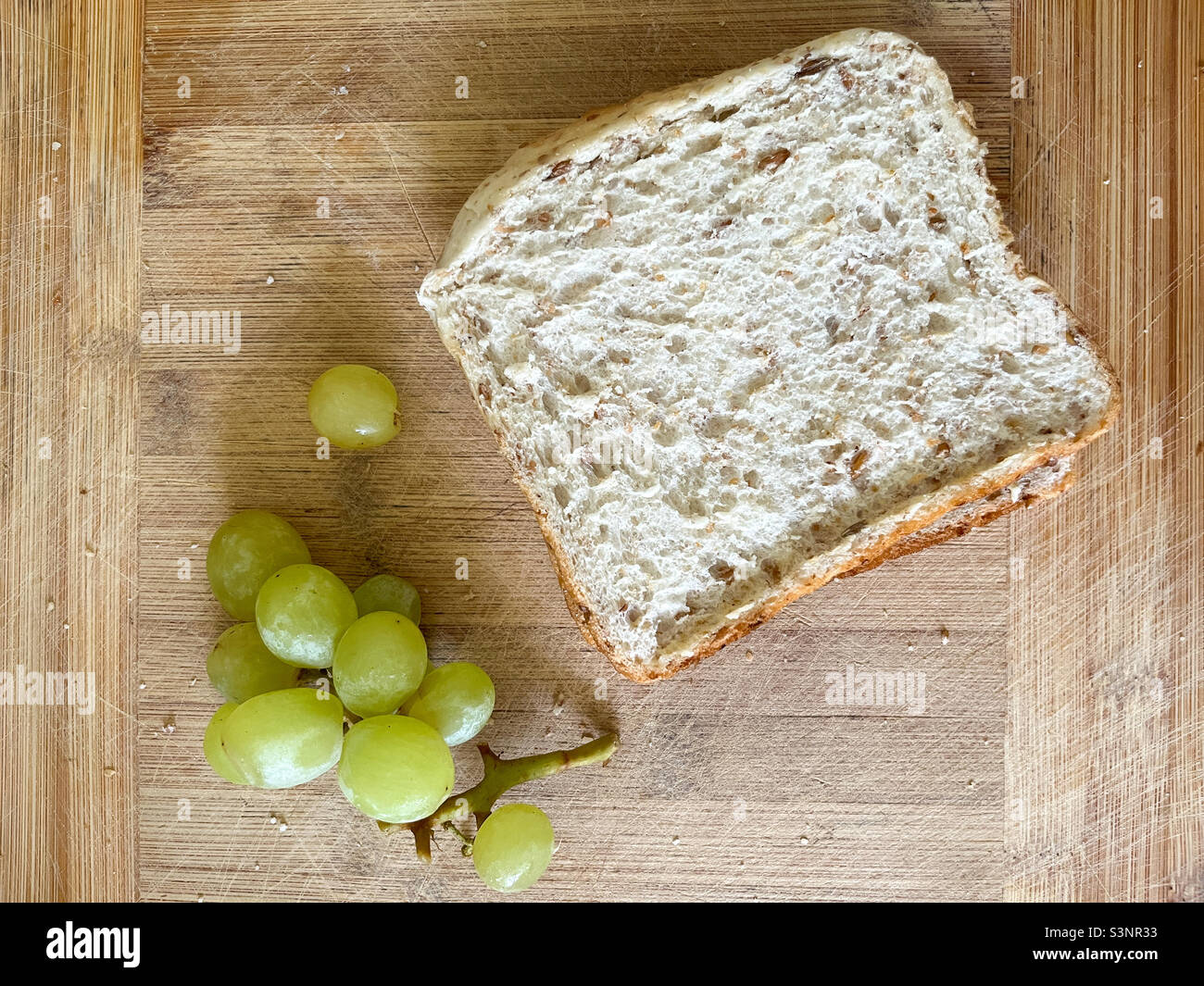 Sandwich und Trauben auf Holzbrett Stockfoto