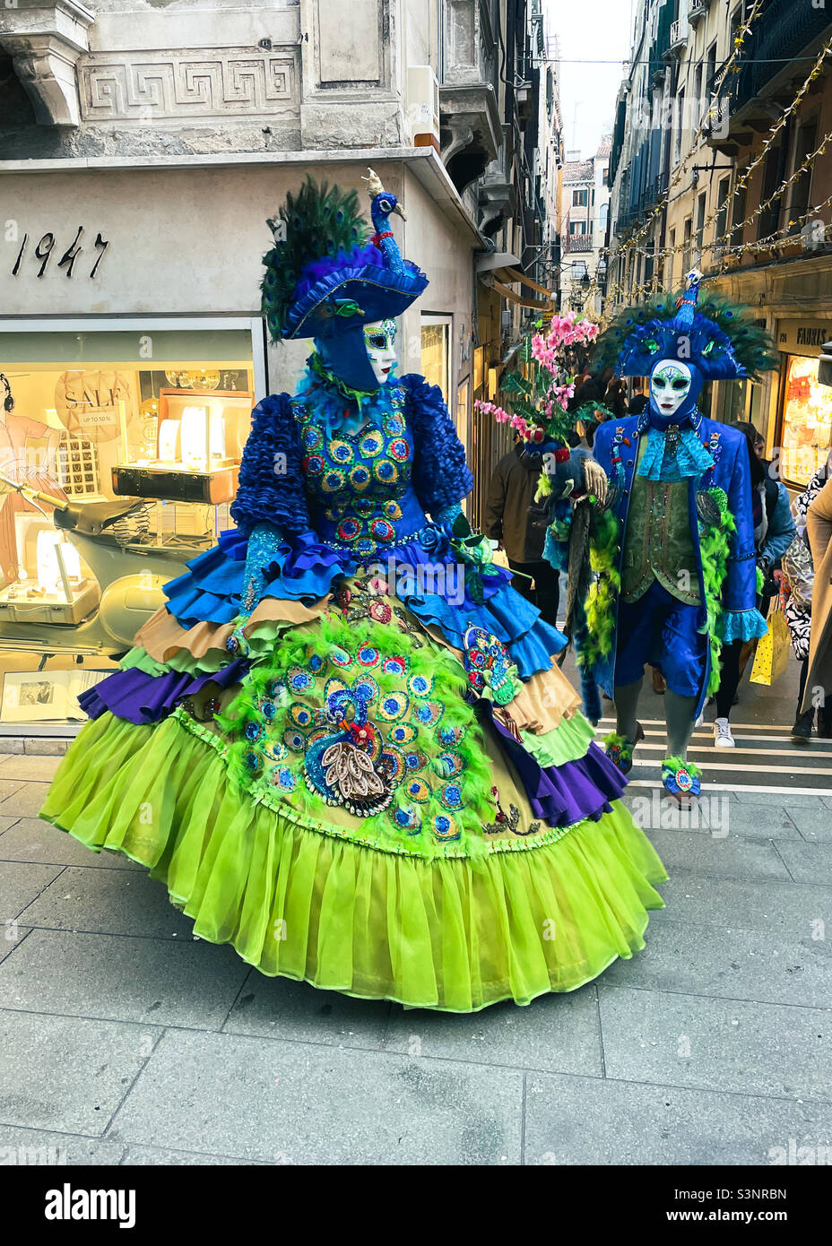 Paar in aufwendigen traditionellen Kostümen, die während der Karnevalsfeiern durch die Straßen von Venedig, Italien, spazieren. Stockfoto