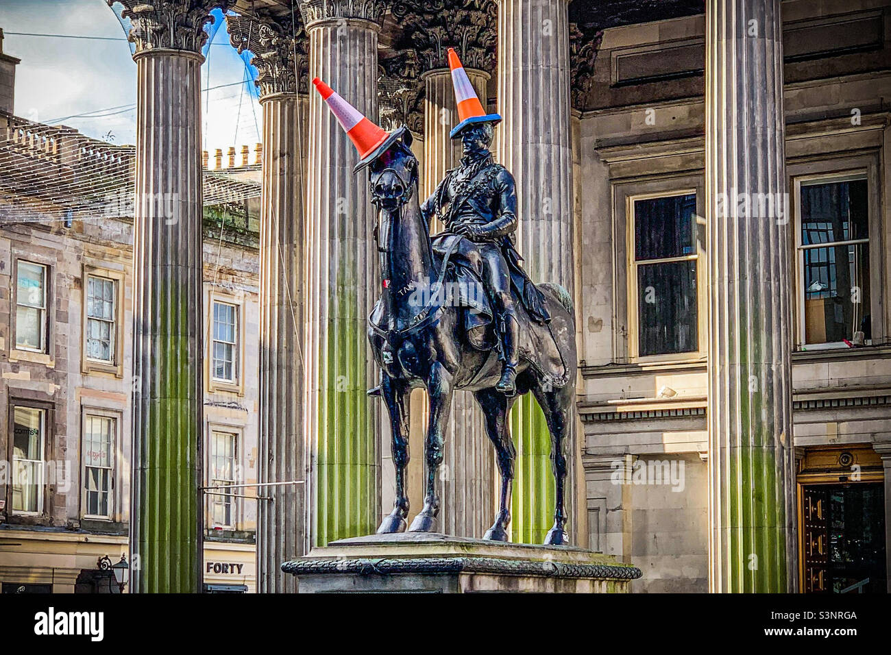 Reiterstatue von Arthur Wellesley, 1. Duke of Wellington mit einem Verkehrskegel auf dem Kopf, vor der Gallery of Modern Art in Glasgow, Schottland - Smartphone-aufgenommenes Stockfoto