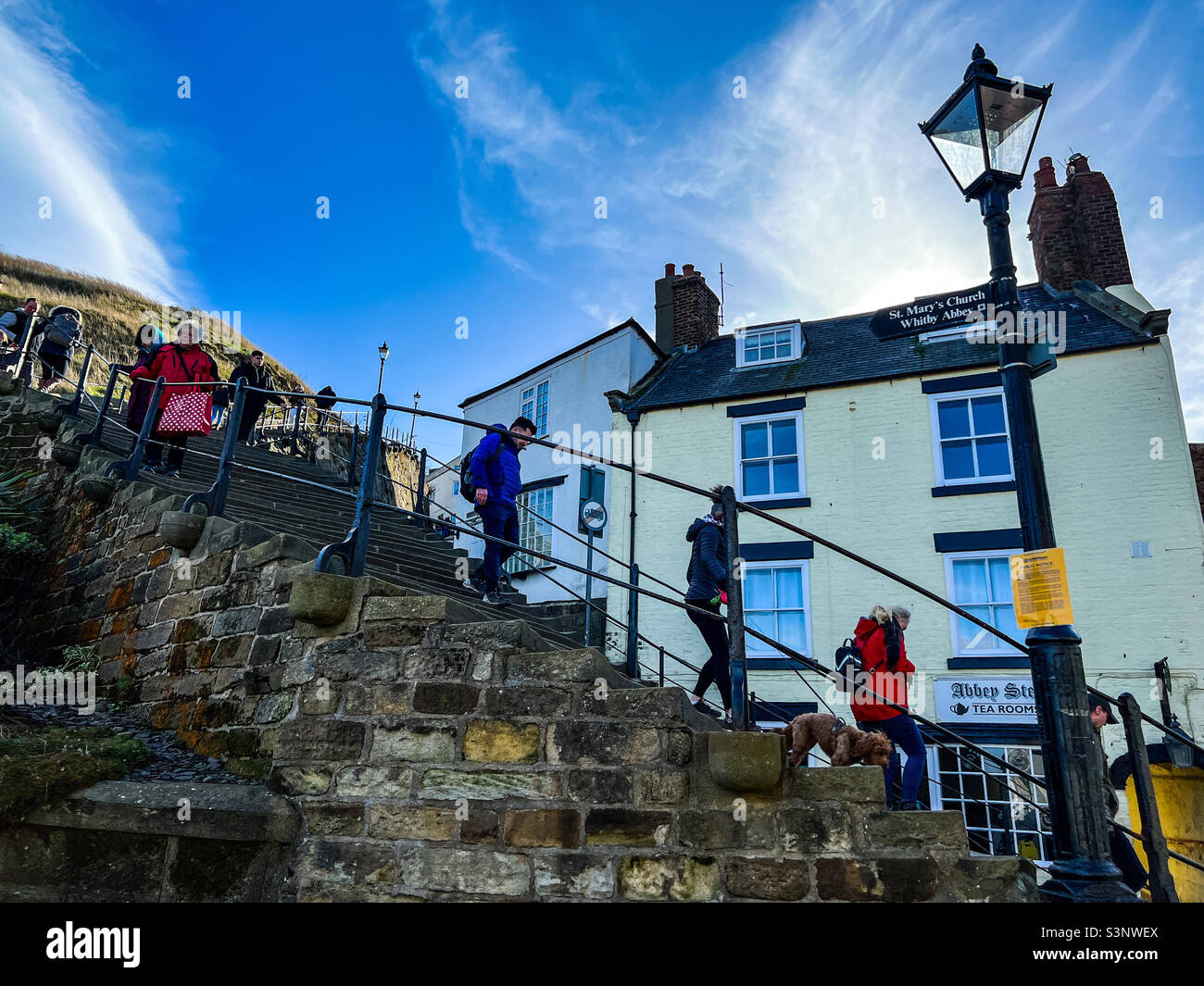 Menschen gehen auf den 199 Stufen der Church Lane in Whitby Stockfoto