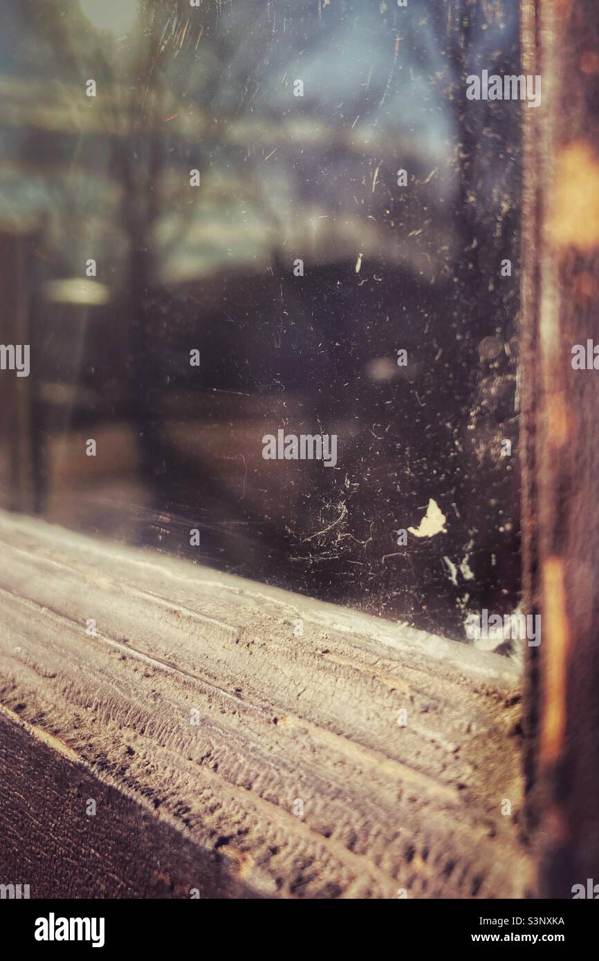 Alt verwittert, Holzfensterrahmen mit Textur, Glas Kratzer und Flecken, nostalgisches Gefühl mit Reflexion. - Smartphone-aufgenommenes Stockfoto