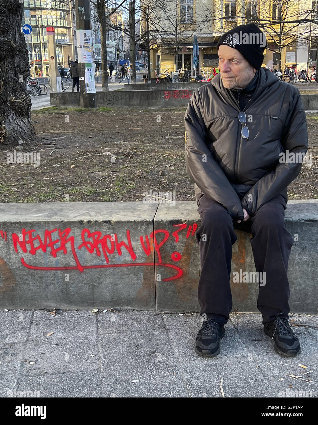Älterer Mann, der auf einer Bank sitzt und nie Graffiti aufwachsen lässt - Mitte, Berlin, Deutschland Stockfoto