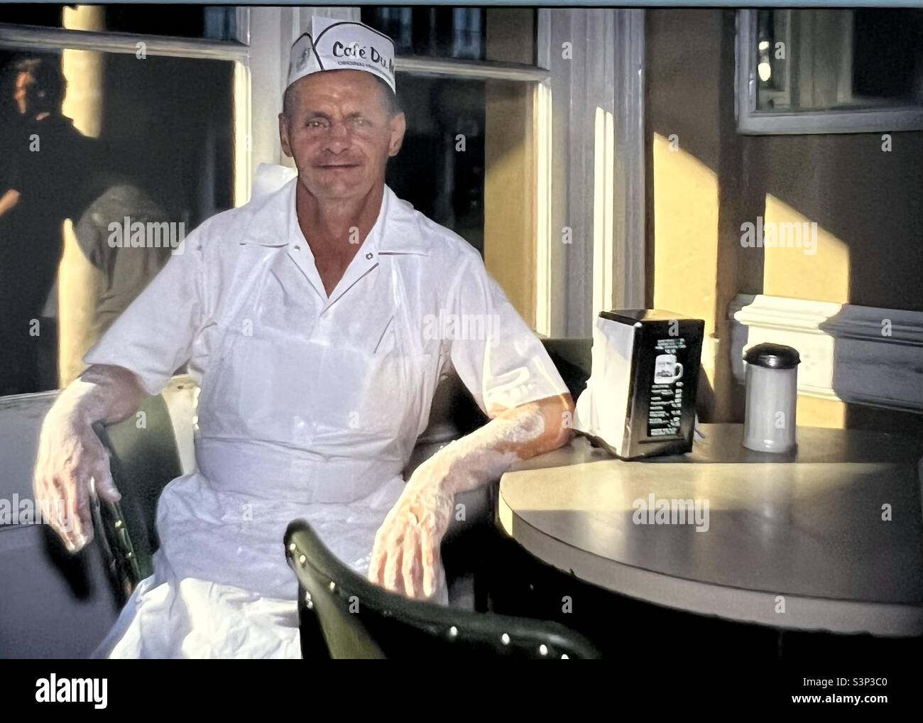 Baker im Cafe Du Monde am Tisch in der Pause in New Orleans Stockfoto