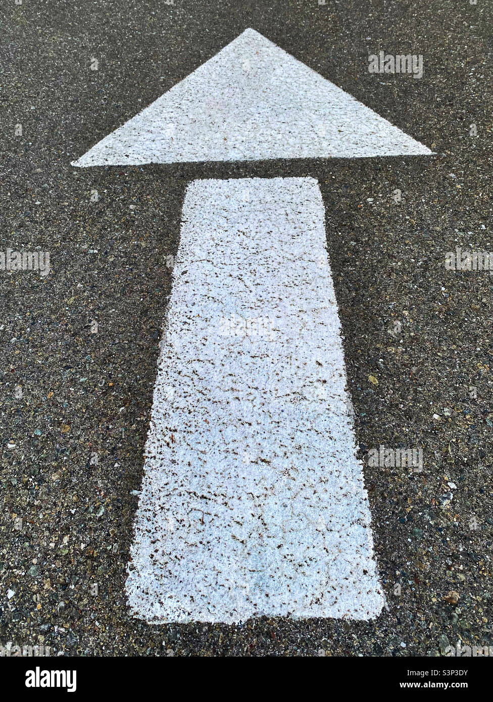 Weißer Pfeil auf Gehsteig weiß Stockfoto