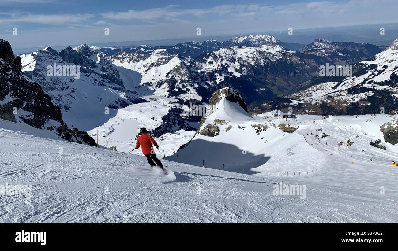 Skifahrer auf der Piste am Titlis mit Blick nach Engelberg, Schweiz. Stockfoto