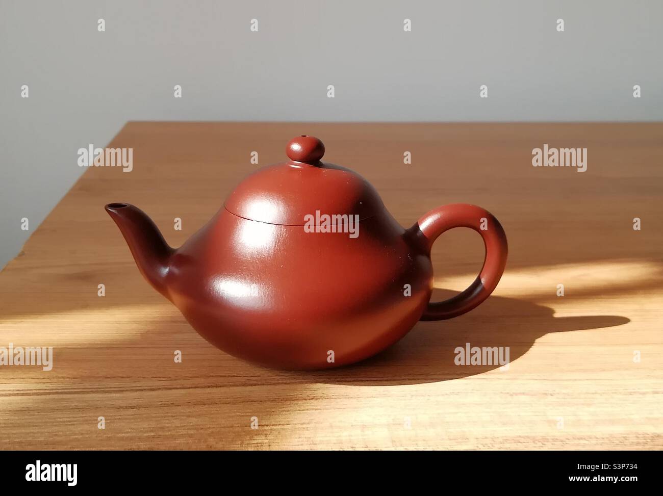 Handgefertigte Yixing Zisha Teekanne aus lila-rotem Ton in Birnenform, die die komplizierte Kunstfertigkeit und reiche Tradition der chinesischen Teekultur zeigt - Smartphone-aufgenommenes Stockfoto