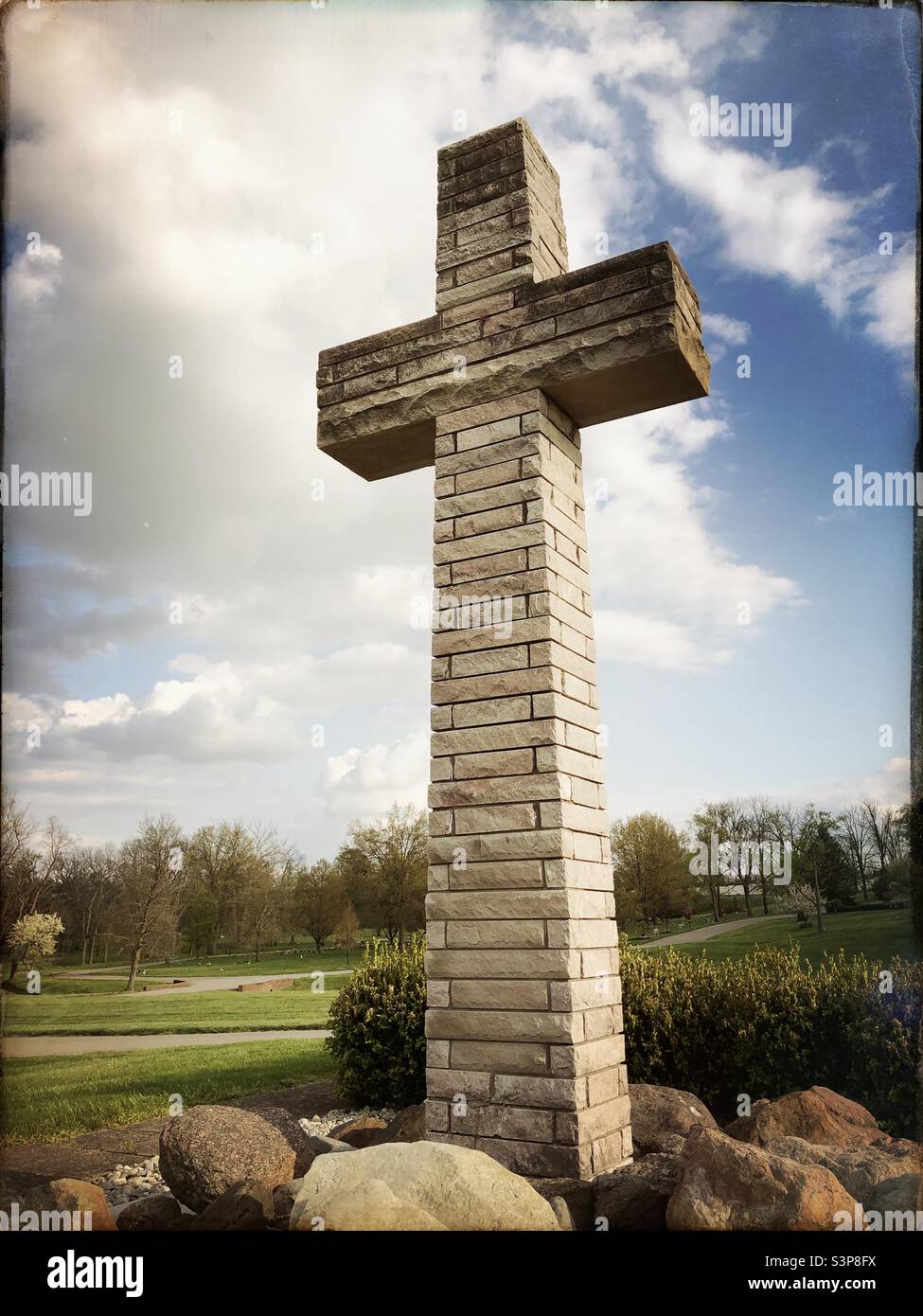 Ein Steinkreuz auf einem Friedhof, das mit einer Hipstamatic-App aufgenommen wurde. 1 - Smartphone-aufgenommenes Stockfoto