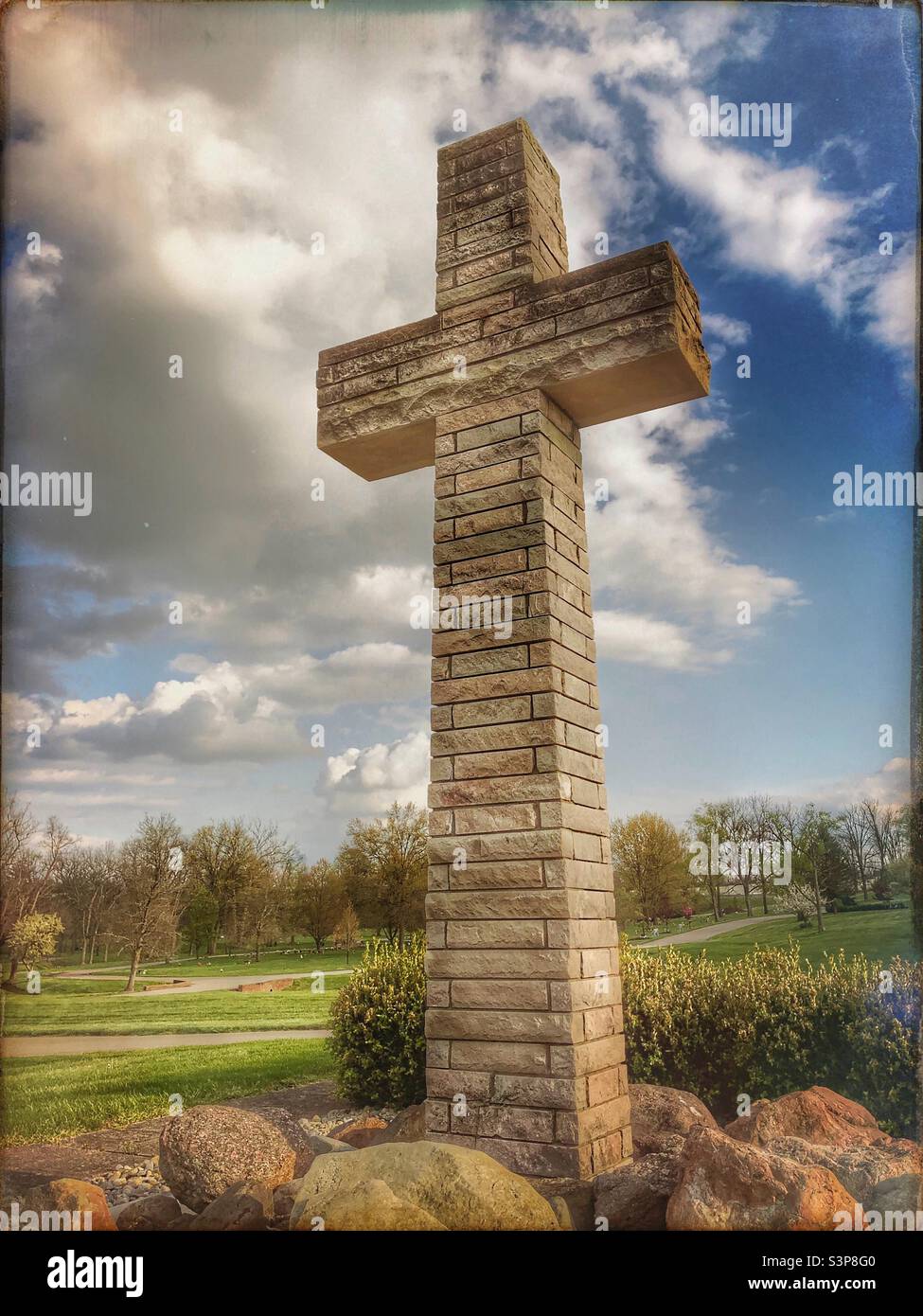 Ein Steinkreuz auf einem Friedhof, das mit einer Hipstamatic-App aufgenommen wurde. 2 - Smartphone-aufgenommenes Stockfoto