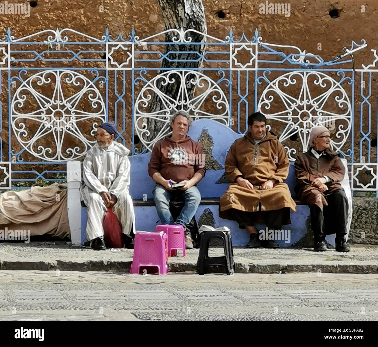Marokkanische Männer sitzen auf einer Bank in Chefchaouen, Marokko. Stockfoto