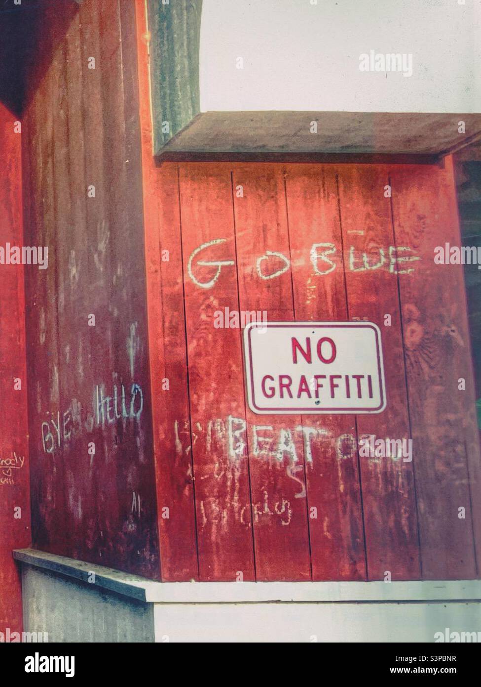 Ein Schild ohne Graffiti an einer roten Wand, umgeben von Graffiti; Go Blue, Beat OSU (Mextures Filter). Stockfoto