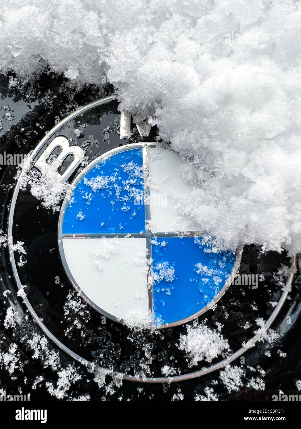 Mit Schnee bedecktes BMW-Logo-Emblem - Smartphone-aufgenommenes Stockfoto