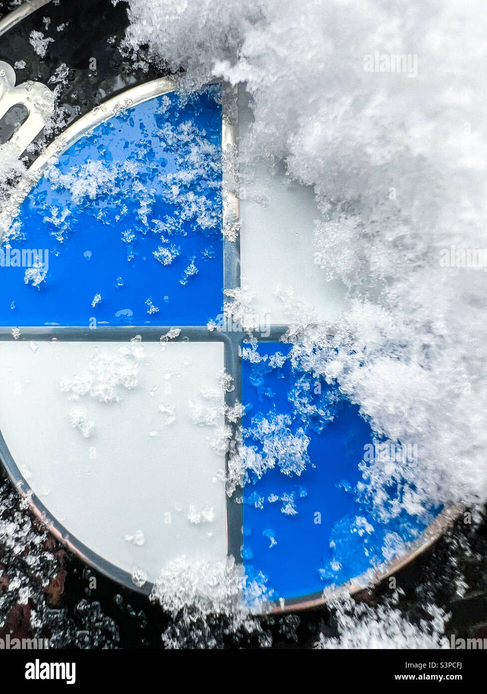 Mit Schnee bedecktes BMW-Logo-Emblem - Smartphone-aufgenommenes Stockfoto