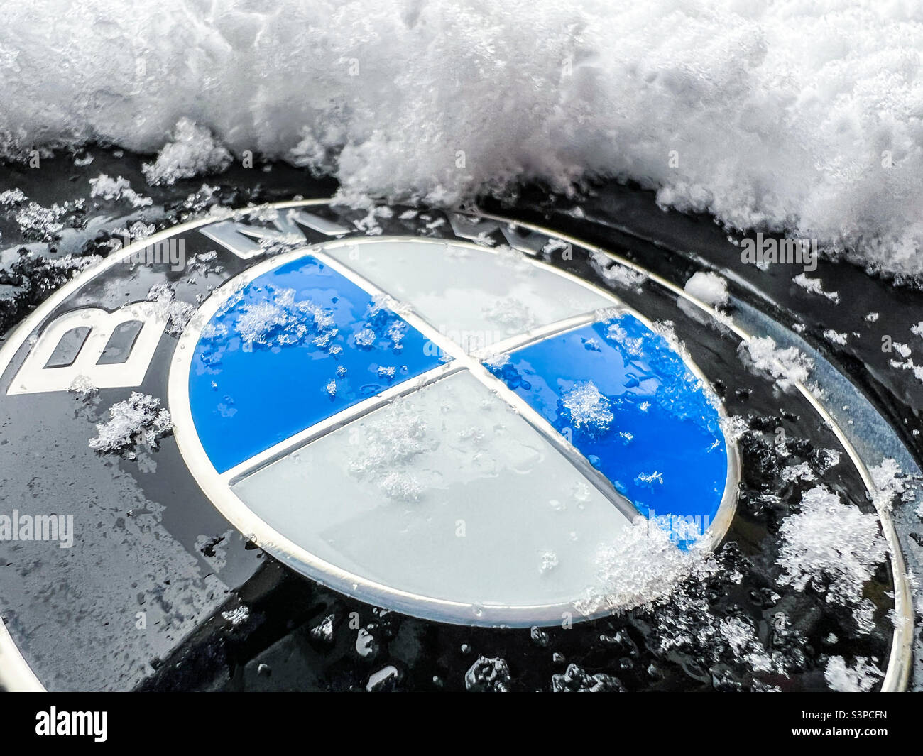 Mit Schnee bedecktes BMW-Logo-Emblem - Smartphone-aufgenommenes Stockfoto