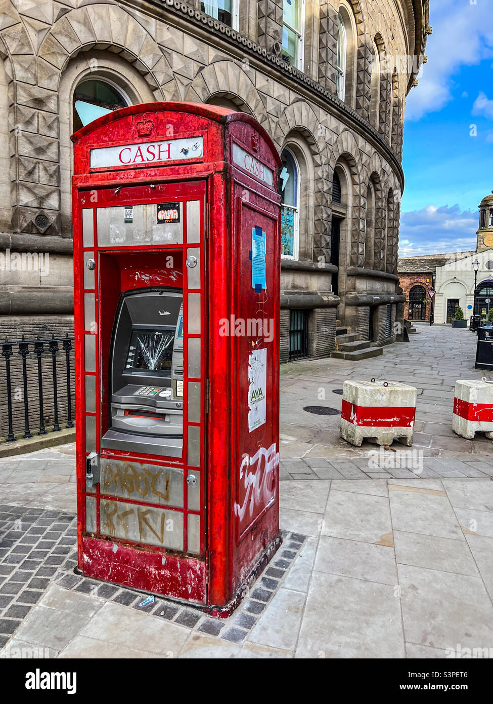 Altmodischer roter Telefonkasten als geldautomat, der in Leeds West Yorkshire zerstört wurde Stockfoto