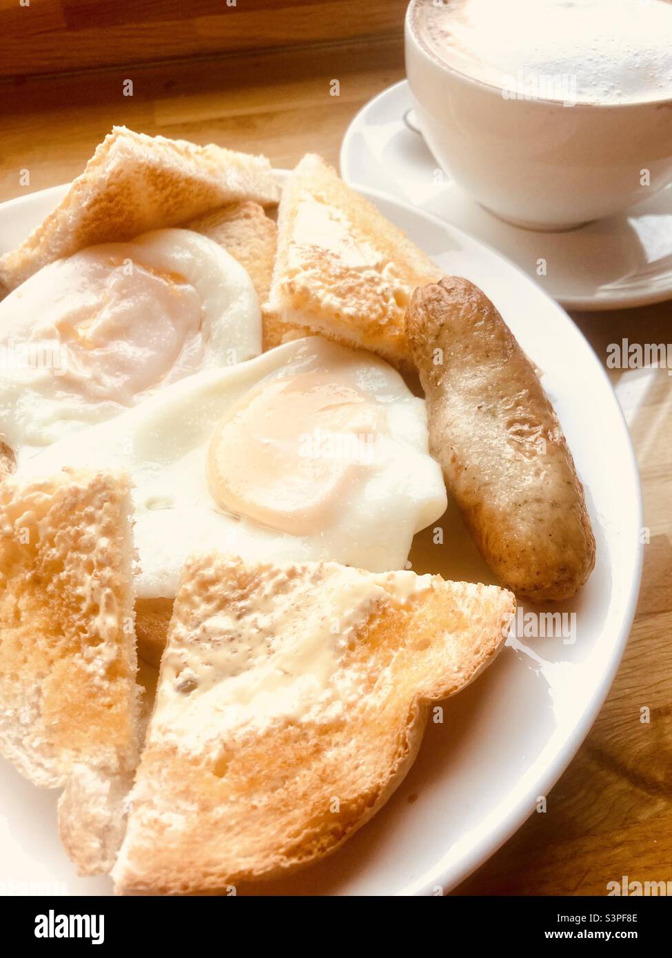 Würstchen und Eier auf Toast mit Cappuccino Stockfoto