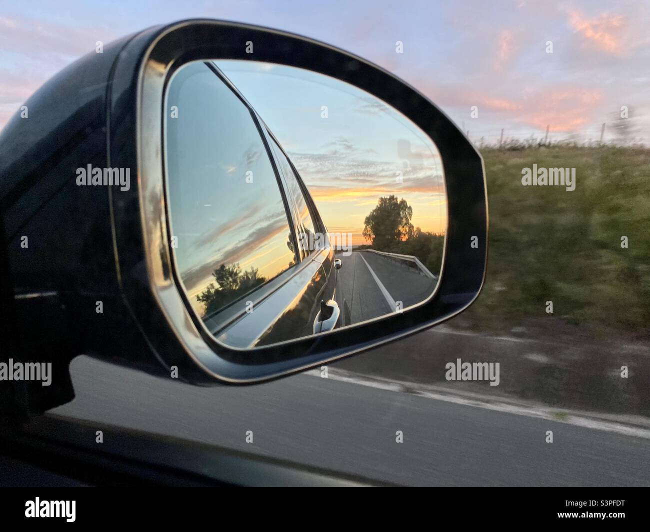 Der Sonnenuntergang spiegelte sich im Spiegel eines Autos wider Stockfoto