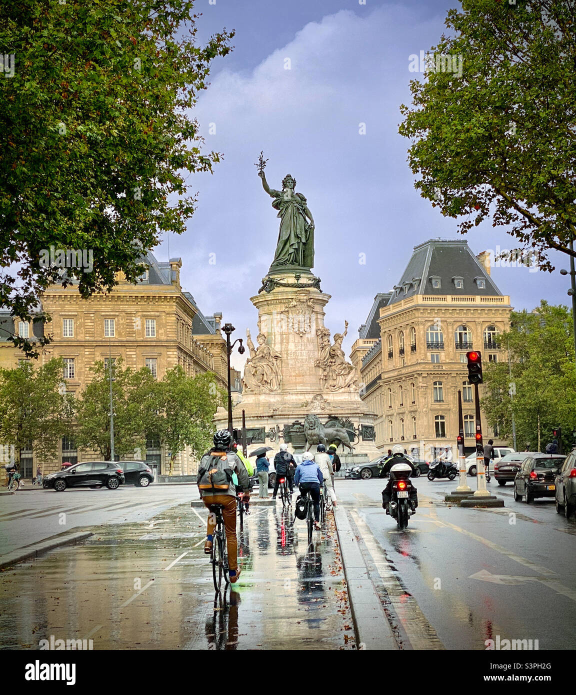 Pendeln mit dem Fahrrad an einem regnerischen Pariser Tag. Place de la République, Paris, Frankreich Stockfoto