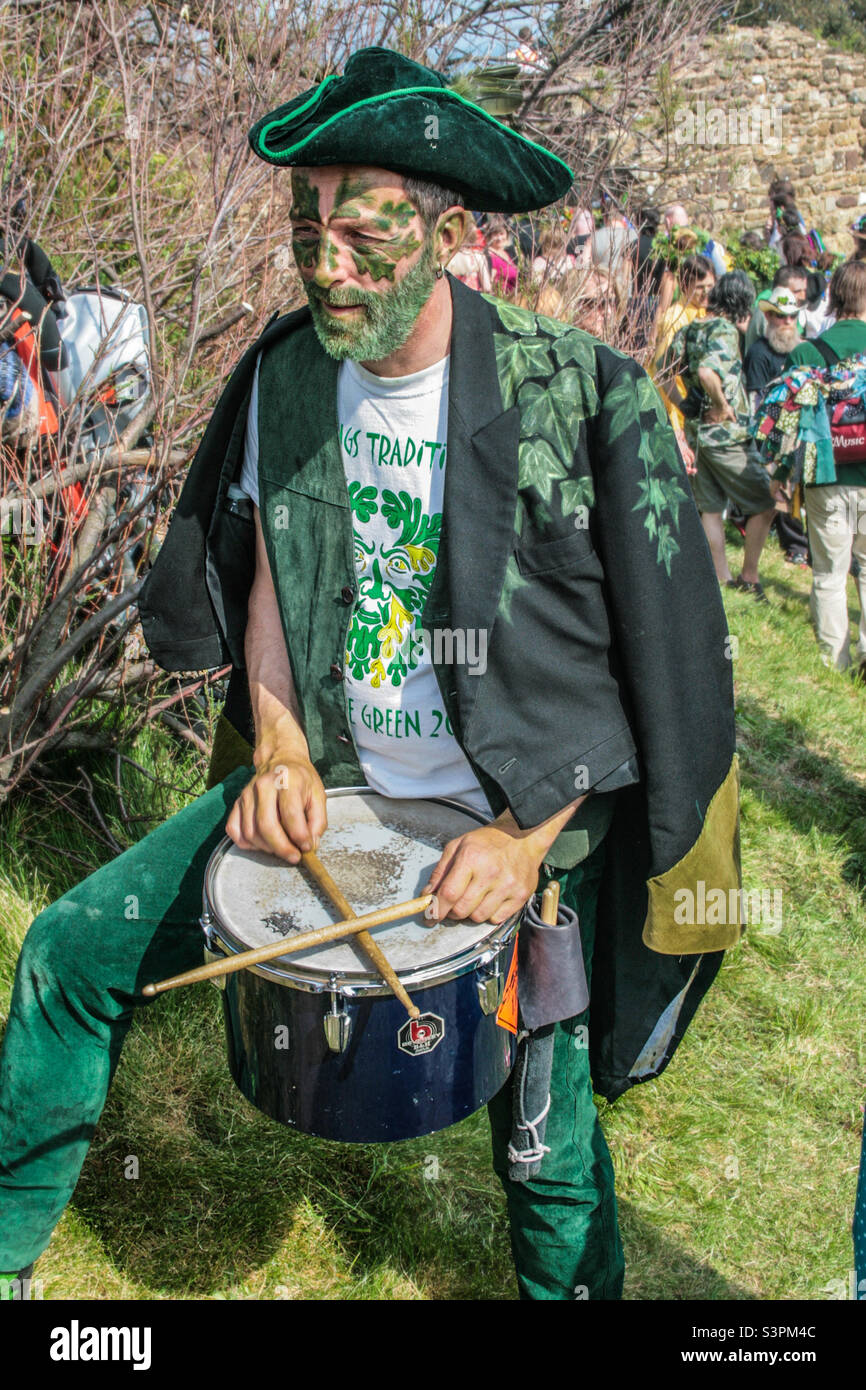 Ein Schlagzeuger mit grüner Gesichtsfarbe steht bei den traditionellen Hastings Jack in the Green Festlichkeiten entspannt da. Großbritannien, Mai 2008 - Smartphone-aufgenommenes Stockfoto