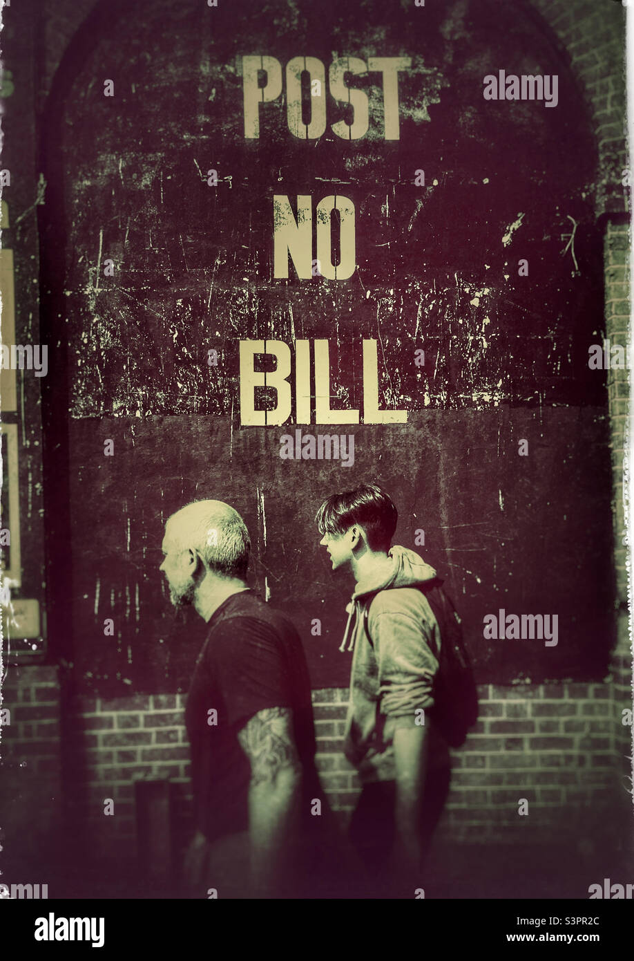 Zwei Männer gehen an einem Post No Bill-Schild in London vorbei Stockfoto