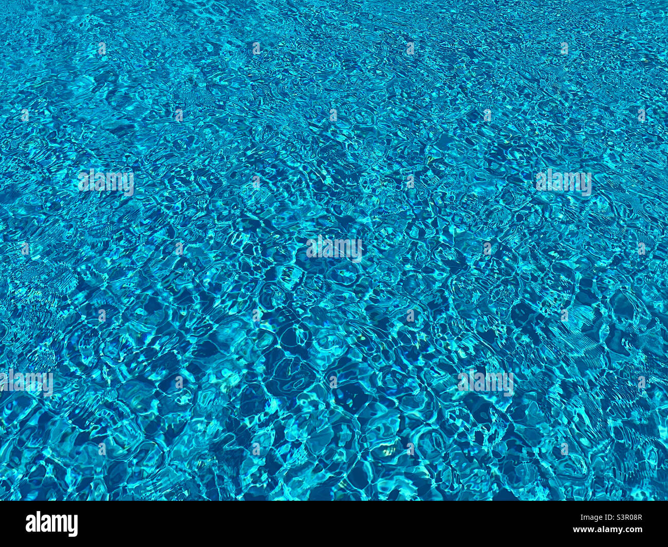 Das glitzernde Wasser eines Swimmingpools. Die Szene von Glück, Entspannung und das Gefühl, im Urlaub zu sein. Ein mögliches Bild für einen Hintergrund? Foto ©️ COLIN HOSKINS. Stockfoto