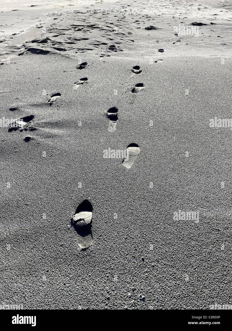 Fußspuren von Fußspuren über den Sand am Kawhia Beach in Neuseeland Stockfoto
