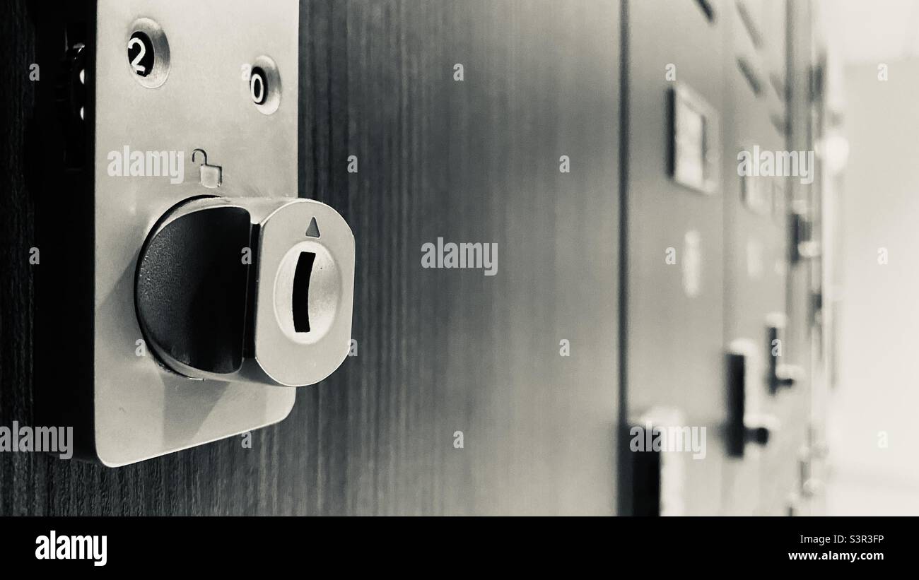 Fokus auf Schloss mit Softfokus Reihe von Umkleidekabinen im Hintergrund. Schwarz und Weiß - Smartphone-aufgenommenes Stockfoto