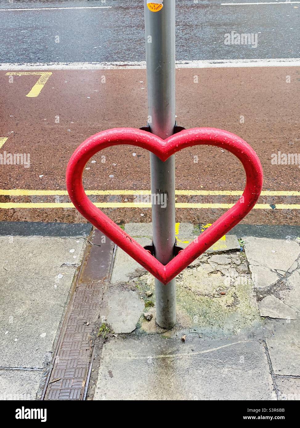 Street Art Herz aus rotem Metall auf einem Laternenpfahl in Großbritannien Stockfoto