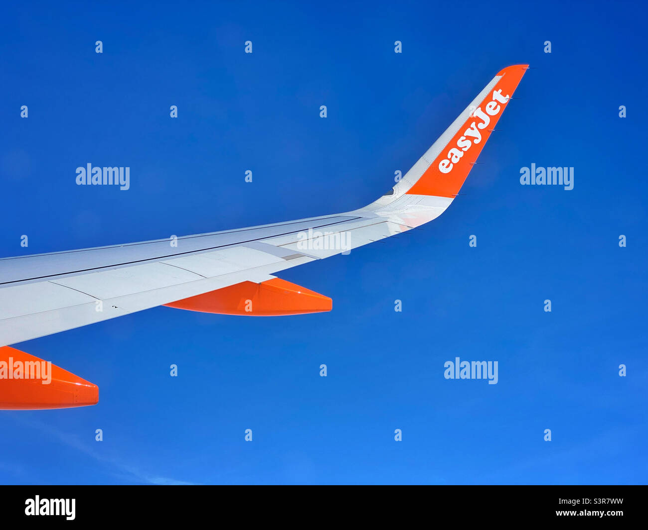 EasyJet fliegt hoch und durch einen tiefblauen Himmel. Blick auf den Airbus-Flügel von Sitz 23F. Foto ©️ COLIN HOSKINS. Stockfoto